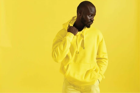 Person in a yellow hoodie on a yellow background
