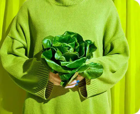 Person holding greens in green sweater