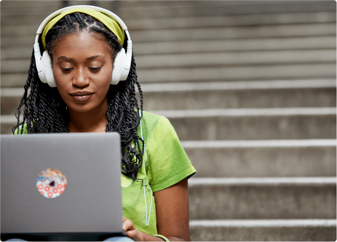 Woman wearing headphones working on her laptop