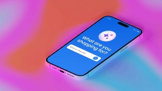 Isometric illustration of a smartphone with a blue screen displaying a shopping assistant interface. The screen shows the text 'What are you shopping for?' with a subtitle 'What can I help with?' below it. A white input field and blue send button are visible. A purple sparkle icon is displayed at the top of the screen. The phone is angled against a gradient background transitioning from pink and coral tones on the left to blue and turquoise on the right.